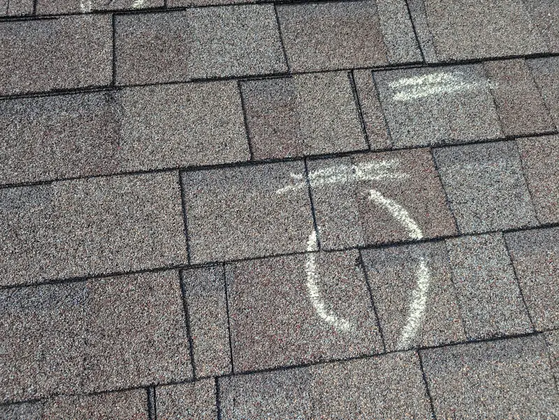 Hail hits marked with chalk during a roof inspection in Lewisville, TX