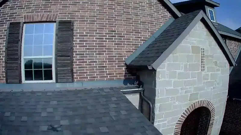 Close-up of shingles and flashing at a dormer during a roof inspection